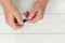 Top view of a person trimming nails with clippers against a wooden surface