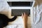 Top view of a person working on the computer next to a dog tail.