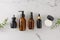 Top view photo of amber cosmetic bottles, cream jar, serum dropper bottle and eucalyptus leaves on marble background