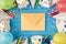 Top view photo of birthday party composition closed craft paper envelope in the middle spiral candles pipes straws hats balloons