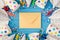 Top view photo of birthday party composition closed craft paper envelope in the middle spiral candles pipes striped straws hats