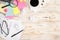 Top view photo of cup of coffee binder clips multicolor sticker note paper magnifier laptop glasses pen notebooks and crumpled