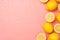 Top view photo of halves and whole yellow lemons on the right water drops on isolated light pink background with blank space on