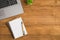 Top view photo of laptop flowerpot and pen on two reminders on isolated wooden table background with copyspace