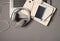 Top view photo of laptop keyboard wired white headset grey pen and mobile phone on two open organizers on isolated grey background