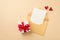 Top view photo of open pastel yellow envelope with paper sheet small red hearts and white giftbox with red ribbon bow on isolated