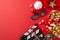 Top-view photo showcasing a movie clapper, 3D glasses, popcorn, Santa\\\'s hat, baubles, star decor on a red background