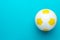 Top view photo of soccer ball over turquoise blue background with copy space.