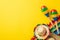 Top view photo of sombrero colorful striped poncho and couple of maracas on isolated vibrant yellow background