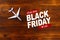 Top view photo of toy airplane over wooden background .Black friday sale