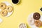 Top view photo of two cups of drink with marshmallow and coffee two plates with different color donuts and cellphone on isolated