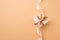 Top view photo of valentine`s day decorations white giftbox with glowing brown and light beige ribbon bow and sequins on isolated