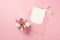 Top view photo of white giftbox with pink satin ribbon bow decorative hearts and open pink envelope with paper sheet on isolated