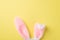 Top view photo of the white and pink tender headband in shape of rabbits ears on the isolated yellow background blank space