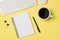 Top view photo of workplace white keyboard mouse open spiral notebook cup of coffee binder clips and pen on isolated light yellow