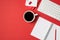 Top view photo of workplace white keyboard red binder clip pencil organizers and cup of coffee on isolated red background with