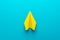 Top view photo of yellow paper plane on turquoise blue background and copy space