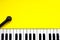 Top view piano keys over yellow background. Pianist musician, pianist concept. Piano And Microphone. Music Keyboard. Copy space