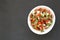 Top view, Pico de Gallo in a white bowl on a black surface. Overhead, from above, flat lay. Space for text