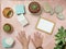 Top view of picture frame mockup, hands, with cactus, rocks, sea shelves and summer decorations on pink sandy table