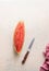 Top view of piece of watermelon on white table with knife. Juicy refreshing summer food