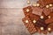 Top view of pieces of chocolate bar with chocolate chips on rustic wooden background. Milk chocolate chunks. Assorted chocolate.