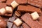 Top view of pieces of chocolate bar with chocolate chips on rustic wooden table background. Chocolate pieces on wooden table. copy