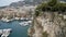 Top view of pier with parked yachts on sea. Action. Beautiful landscape view from rocky coast to seaside town with port