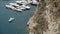 Top view of pier with parked yachts on sea. Action. Motorboat sails near marine Parking lot of expensive white yachts at