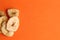 Top view of a pile of banana chips on an orange background