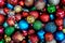 Top view of pile of dark and colorful Christmas balls for an abstract holiday season background backdrop pattern.