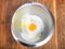 top view of pile of flour with broken egg in bowl