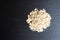 Top view of a pile of oatmeal on a black surface