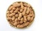 Top view of a pile of raw peanuts also called groundnut on bamboo plate isolated on white background. Food concept.