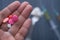 Top view of pills on man hand and syringe on table