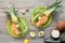 Top view on pineapple boats with smoked salmon and avocado slices with lemon and quail eggs, flat lay on old wooden table