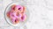 Top view, pink donuts in white dish