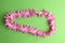 Top view of pink garland paper isolated on a green background