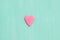 Top view on a pink gingerbread cookie in shape of heart on turquoise background. Flay layout. Love, Valentines`s day concept