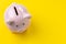 Top view of pink piggy bank on vivid yellow background with copy space, banking, budget, expense and saving concept
