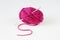Top view of pink yarn ball with woolen thread on white background