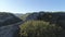 Top view of plantation in mountain valley. Shot. Panorama from stone ridge of rock cliffs to green valley in sunny