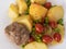 Top view on a plate with boiled potato, rissole, cherry tomatoes