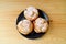 Top View of a Plate of Choux a la Creme French Pastries with Icing Sugar Served on Wooden Table