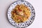 Top view of a plate of cooked rice with vegetables and chicken on a gray surface