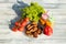 Top view on plate of fresh grilled meat surrounded by fresh salad, tomatoes, paprika and two glasses of freshly squeezed orange j