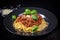Top view of a plate of steaming Spaghetti Bolognese garnished with fresh basil leaves and grated Parmesan cheese