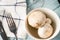 Top view on plate with white common champignon mushrooms on table in bowl