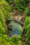 Top view on the Ponte Romano Intragna Bridge hiding in the valley with beautiful river covered with trees, close to