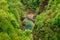 Top view on the Ponte Romano Intragna Bridge hiding in the valley with beautiful river covered with trees, close to